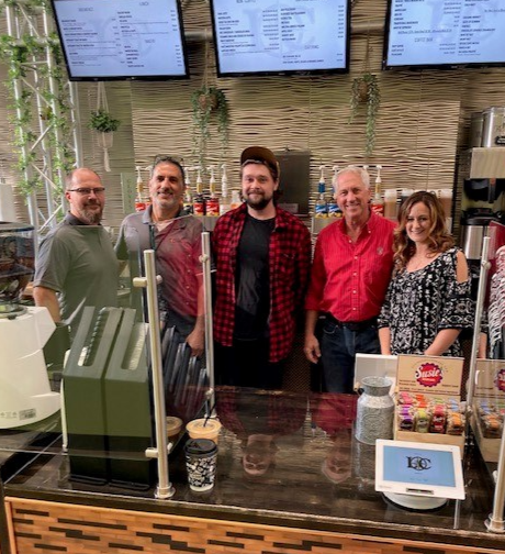 Photo of Senator Dan Knodl behind the counter of Latitude Café in the Menomonee Falls Public Library with cafe owners, a staff member and Supervisor Jeremy Walz.